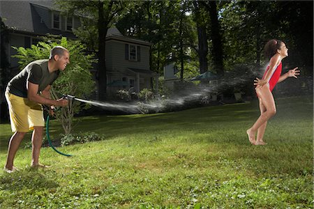 simsearch:600-04625303,k - Father and Daughter Playing with Water Hose in Backyard Foto de stock - Sin royalties Premium, Código: 600-01614322