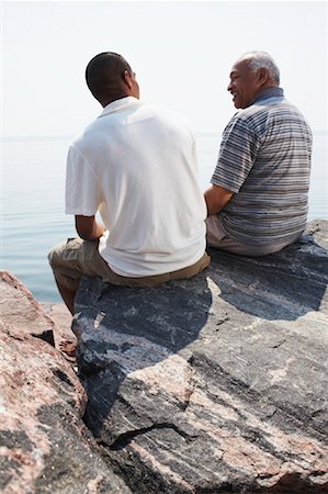 smiling senior people talking family - Father and Son on Rocks by Water Stock Photo - Premium Royalty-Free, Code: 600-01616604