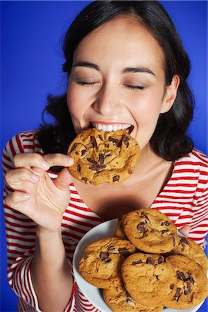 Woman Eating Cookies Stock Photo - Premium Royalty-Free, Code: 600-01613533