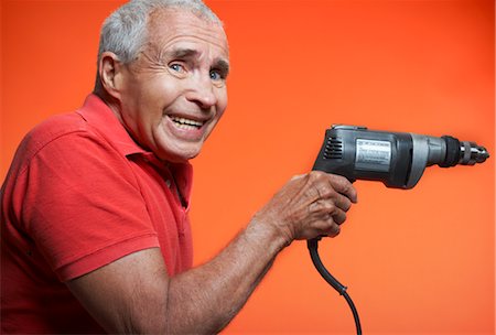 pictures of a man holding a drill - Nervous Man Holding Power Drill Stock Photo - Premium Royalty-Free, Code: 600-01613558