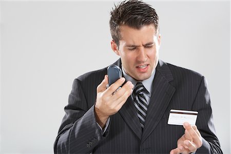 Homme avec un téléphone cellulaire et cartes de crédit Photographie de stock - Premium Libres de Droits, Code: 600-01613636