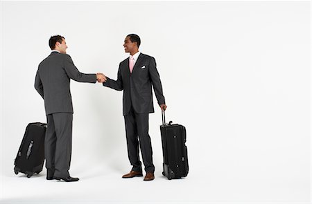 Businessmen With Luggage Shaking Hands Stock Photo - Premium Royalty-Free, Code: 600-01613711