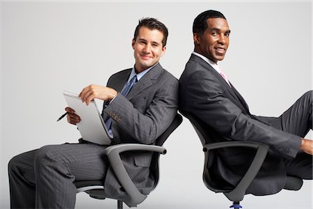 Les hommes d'affaires assis dos à dos dans des chaises de bureau Photographie de stock - Premium Libres de Droits, Code: 600-01613723