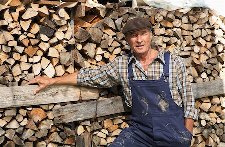 simsearch:600-01644926,k - Farmer Standing by Woodpile Fotografie stock - Premium Royalty-Free, Codice: 600-01644931