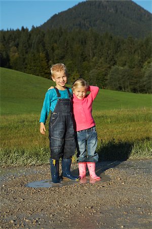 Brother and Sister Standing in Puddle Foto de stock - Sin royalties Premium, Código: 600-01644984