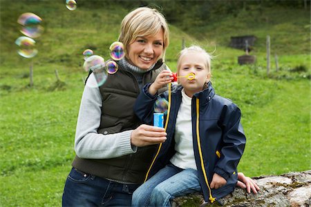 Mother and Daughter Blowing Bubbles Stock Photo - Premium Royalty-Free, Code: 600-01645036