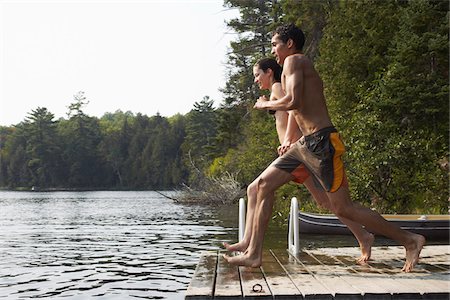 Couple Jumping from Dock Foto de stock - Sin royalties Premium, Código: 600-01670947