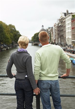 Couple Looking over Canal, Amsterdam, Netherlands Stock Photo - Premium Royalty-Free, Code: 600-01695110