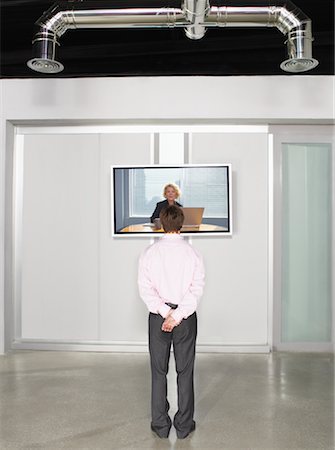 skype - Businessman Videoconferencing with Big Screen Television Foto de stock - Sin royalties Premium, Código: 600-01695645