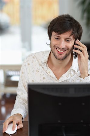 Homme utilisant un ordinateur et téléphone cellulaire Photographie de stock - Premium Libres de Droits, Code: 600-01693964