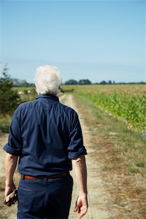 simsearch:600-01716071,k - Farmer Walking by Cornfield Fotografie stock - Premium Royalty-Free, Codice: 600-01715957