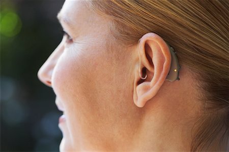 Close-up Of Woman's Ear with Hearing Aid Fotografie stock - Premium Royalty-Free, Codice: 600-01716099