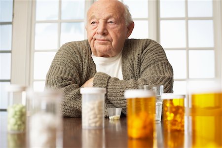 sulking arms folded - Senior Man with Pill Bottles Stock Photo - Premium Royalty-Free, Code: 600-01716092