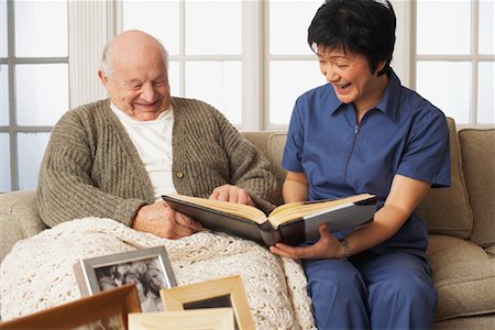 Senior Man with Woman Looking at Pictures Together Stock Photo - Premium Royalty-Free, Code: 600-01716113