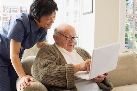 services information technology - Senior Man Using Laptop Computer with Woman Looking over his Shoulder Stock Photo - Premium Royalty-Free, Code: 600-01716120