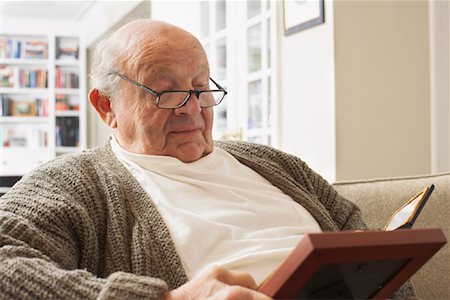 reminiscing photos - Senior Man Looking at Pictures Stock Photo - Premium Royalty-Free, Code: 600-01716121