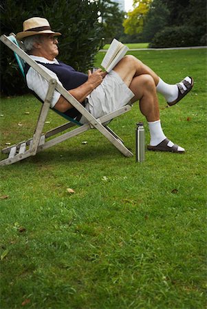 Man Sitting in Lawn Chair, Reading Book Stock Photo - Premium Royalty-Free, Code: 600-01717984