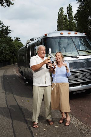 Couple Standing by Trailer, Celebrating With Champagne Stock Photo - Premium Royalty-Free, Code: 600-01718005