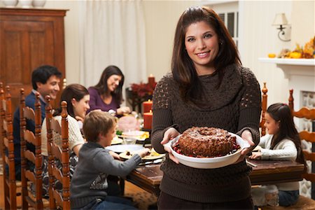 Woman Holding Dessert at Family Dinner Stock Photo - Premium Royalty-Free, Code: 600-01742541