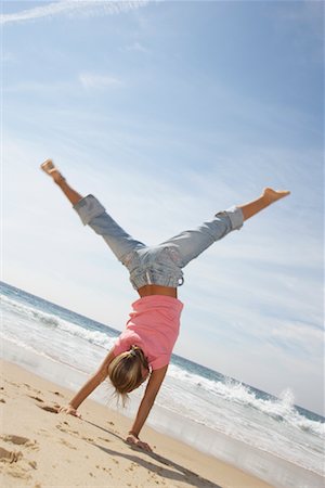 simsearch:600-01540626,k - Girl Performing Cartwheel on Beach Foto de stock - Royalty Free Premium, Número: 600-01742850