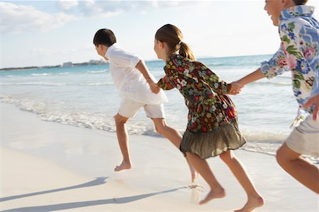 sister and brother running on beach in summer - Children Running on the Beach Stock Photo - Premium Royalty-Free, Code: 600-01755491