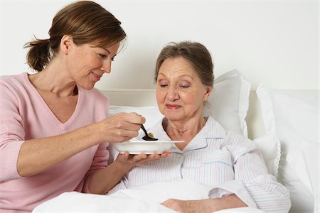 family eating cereal - Caregiver Feeding Senior Woman Stock Photo - Premium Royalty-Free, Code: 600-01764474