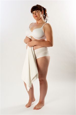 fat belly white background - Portrait of Woman in Underwear Holding Towel Stock Photo - Premium Royalty-Free, Code: 600-01765018