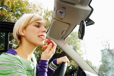 simsearch:600-01827052,k - Woman Applying Lipstick While Driving Foto de stock - Royalty Free Premium, Número: 600-01827048