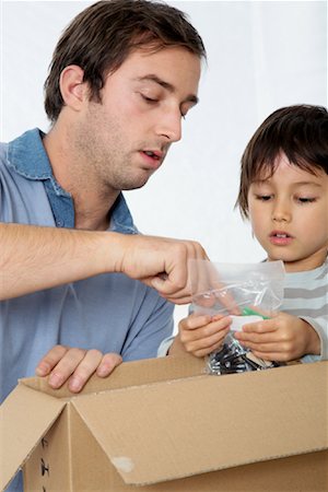 father explain child - Father and Son Looking through Box Stock Photo - Premium Royalty-Free, Code: 600-01827128