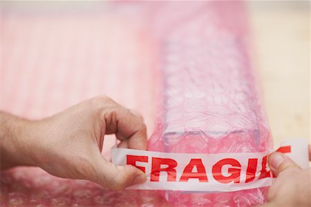 Man's Hands Wrapping Fragile Goods Stock Photo - Premium Royalty-Free, Code: 600-01827184