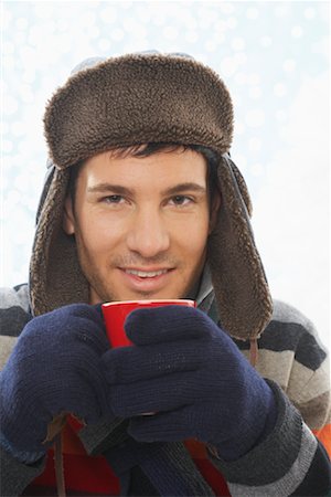 person in gloves holding cup of hot cocoa - Man Drinking Hot Chocolate Stock Photo - Premium Royalty-Free, Code: 600-01838485