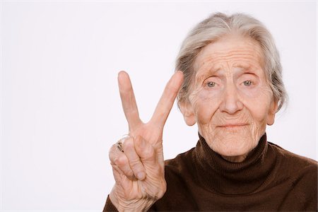 Woman Making Peace Sign Stock Photo - Premium Royalty-Free, Code: 600-01879179