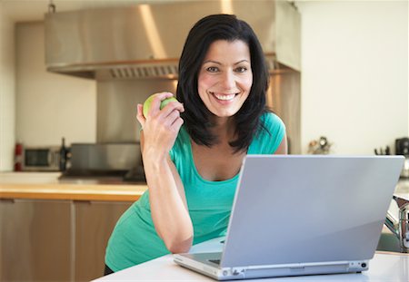 simsearch:600-02010371,k - Woman with Laptop and Apple in Kitchen Foto de stock - Sin royalties Premium, Código: 600-01954839