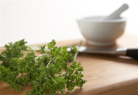 Parsley, Knife and Mortar and Pestle on Cutting Board Stock Photo - Premium Royalty-Free, Code: 600-01955552