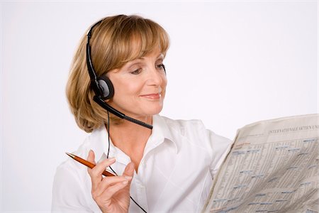 Woman with Headset and Newspaper Stock Photo - Premium Royalty-Free, Code: 600-01955835