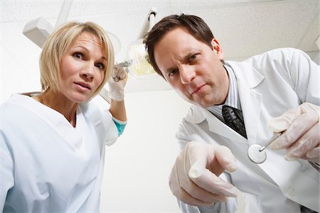 simsearch:600-01993016,k - Dentists Wincing While Working Stock Photo - Premium Royalty-Free, Code: 600-01993015