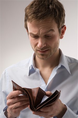 photographic portraits poor people - Man Looking in Empty Wallet Stock Photo - Premium Royalty-Free, Code: 600-02010054