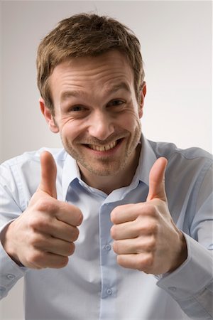simsearch:600-02010065,k - Portrait of Man Giving Thumbs Up Fotografie stock - Premium Royalty-Free, Codice: 600-02010060