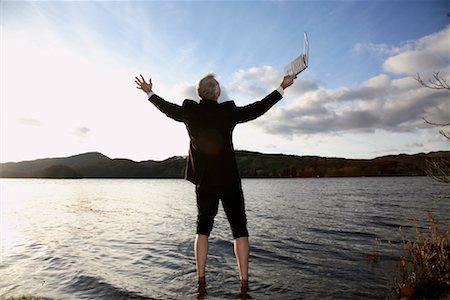 suit man standing backside - Businessman with Laptop Computer Standing in Lake Windermere, Cumbria, England Stock Photo - Premium Royalty-Free, Code: 600-02010373