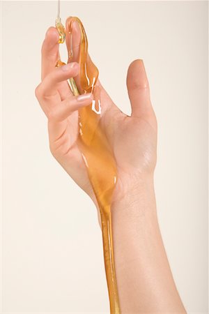 Honey Pouring over Hand Stock Photo - Premium Royalty-Free, Code: 600-02010536