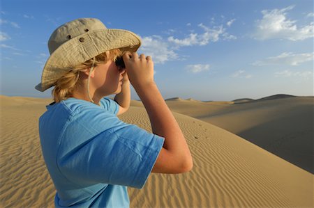 Boy Looking Out Over Sand Dunes Through Binoculars, Playa del Ingles, Cran Canaria, Canary Islands Stock Photo - Premium Royalty-Free, Code: 600-02046304