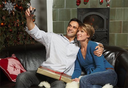 female holding christmas present - Couple Taking Photo of Themselves at Christmas Stock Photo - Premium Royalty-Free, Code: 600-02071857