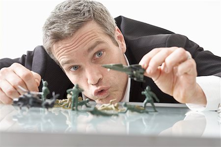 Homme d'affaires jouant avec Toy Soldiers sur le Bureau Photographie de stock - Premium Libres de Droits, Code: 600-02081698