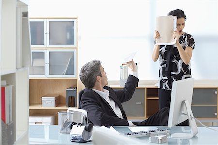 Businessman Throwing Paper Airplane at Businesswoman in Office Stock Photo - Premium Royalty-Free, Code: 600-02081707