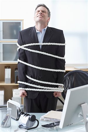 simsearch:700-00089070,k - Businessman Tied Up with Rope at Desk Stock Photo - Premium Royalty-Free, Code: 600-02081767