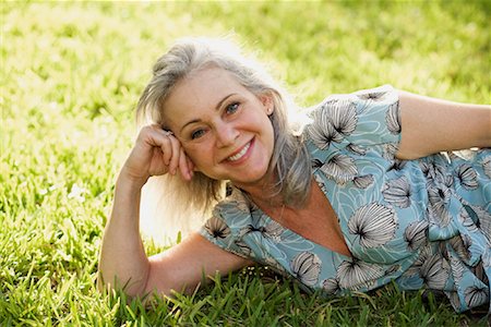 pretty gray hair smiling - Portrait of Woman Lying Down on Grass Stock Photo - Premium Royalty-Free, Code: 600-02129029