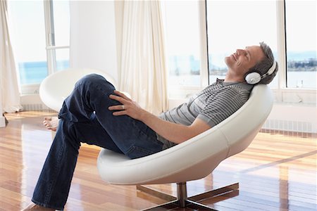 relaxing wood floor guy - Man with Headphones in Condominium Stock Photo - Premium Royalty-Free, Code: 600-02130667