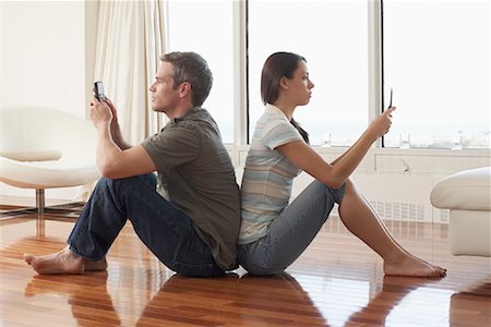 Couple with Cellular Phones in Condominium Stock Photo - Premium Royalty-Free, Code: 600-02130714