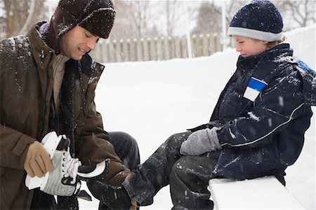 people outdoors winter activity - Father Helping Son Put on Skates Stock Photo - Premium Royalty-Free, Code: 600-02200079