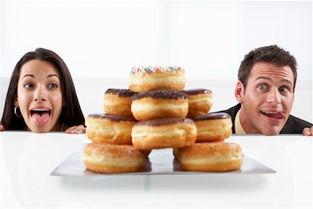 sticking out her tongue - People Stalking Doughnuts Stock Photo - Premium Royalty-Free, Code: 600-02201159